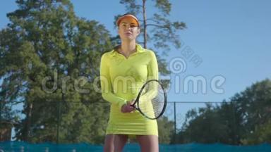 穿着运动服的漂亮女孩站在网球场上时拿着<strong>网球拍</strong>。 <strong>年轻</strong>的网球运动员